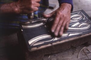 Nenek Tulian carving a panel