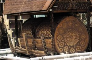 A coffin containing the deceased, wrapped in cloth with gold decoration.